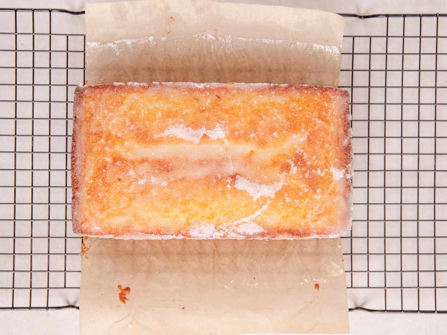 Lemon cake on parchment paper on cooling rack