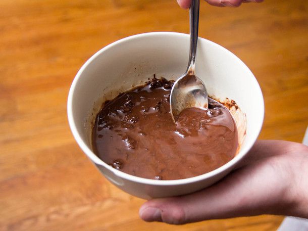 Author continues to stir the chocolate dip together. The chocolate is almost fully melted and the mixture is starting to look smooth and emulsified.