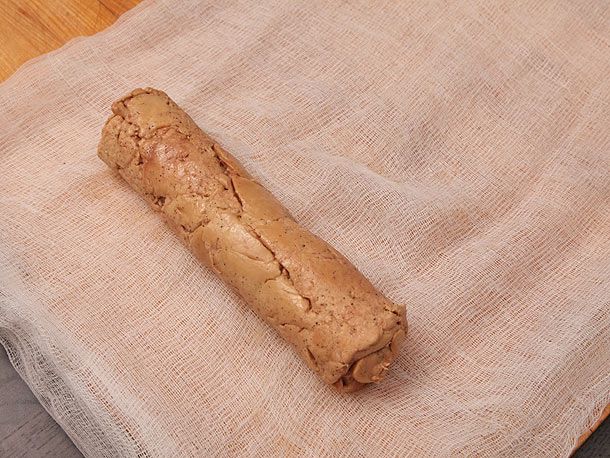 Rolled foie gras prepared to be rolled again in a cheesecloth. 