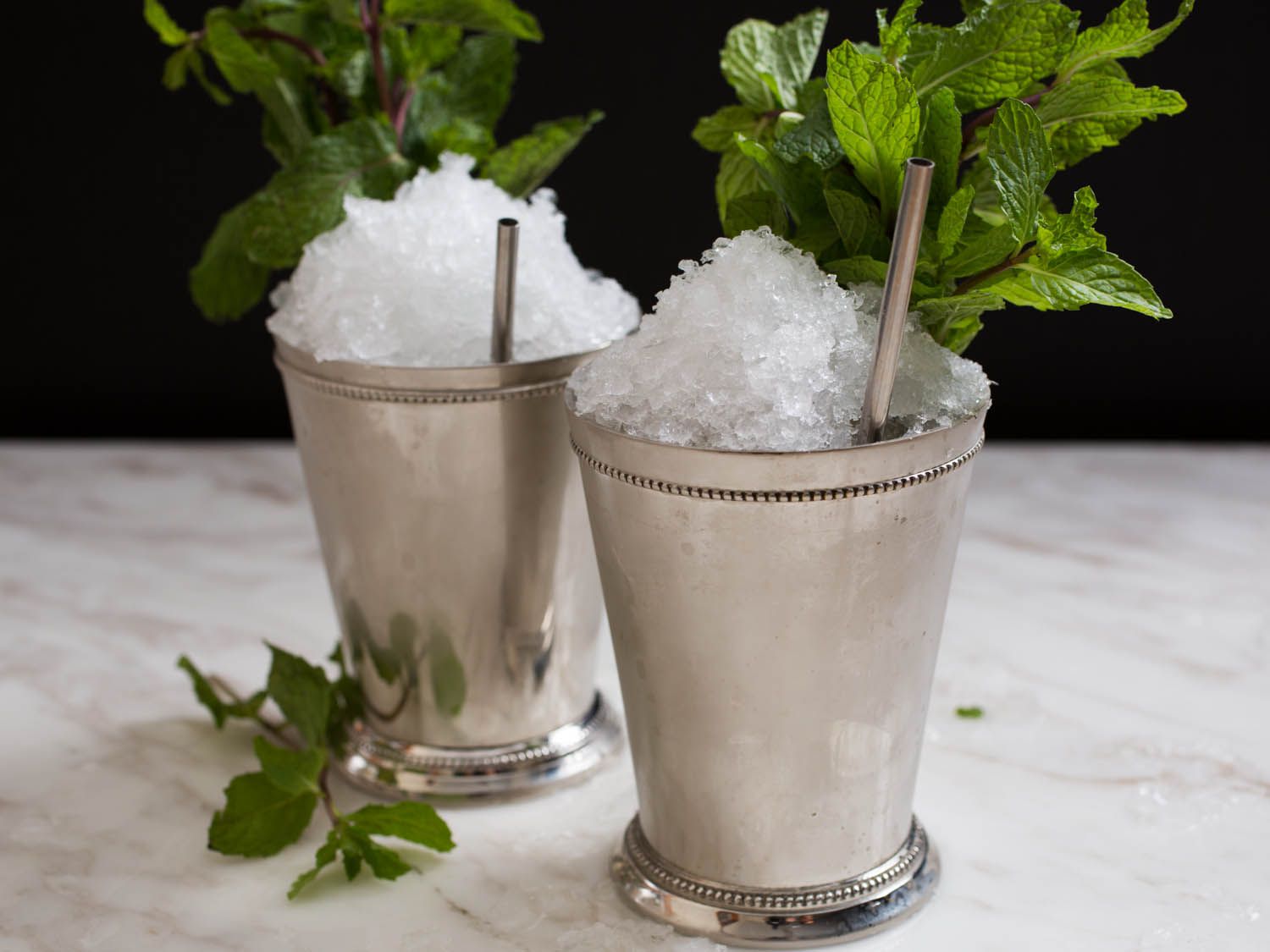 Two icy Mint Juleps in silver cups with silver straws