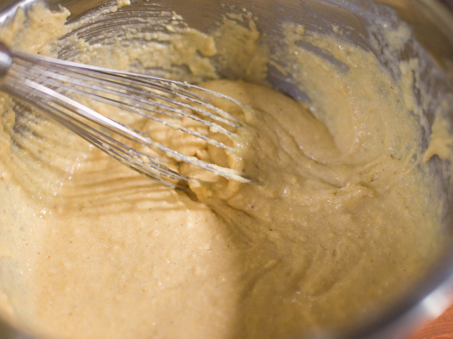 Combining wet and dry ingredients with a whisk for cornbread.