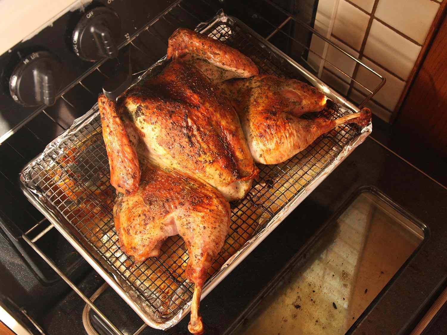 Herb-Rubbed Crisp-Skinned Butterflied Roast Turkey on a rack in the oven.