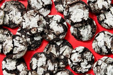 Chocolate crinkle cookies arranged on a red surface