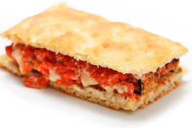 A fried-eggplant sandwich with eggplant mayo, set on a white surface.