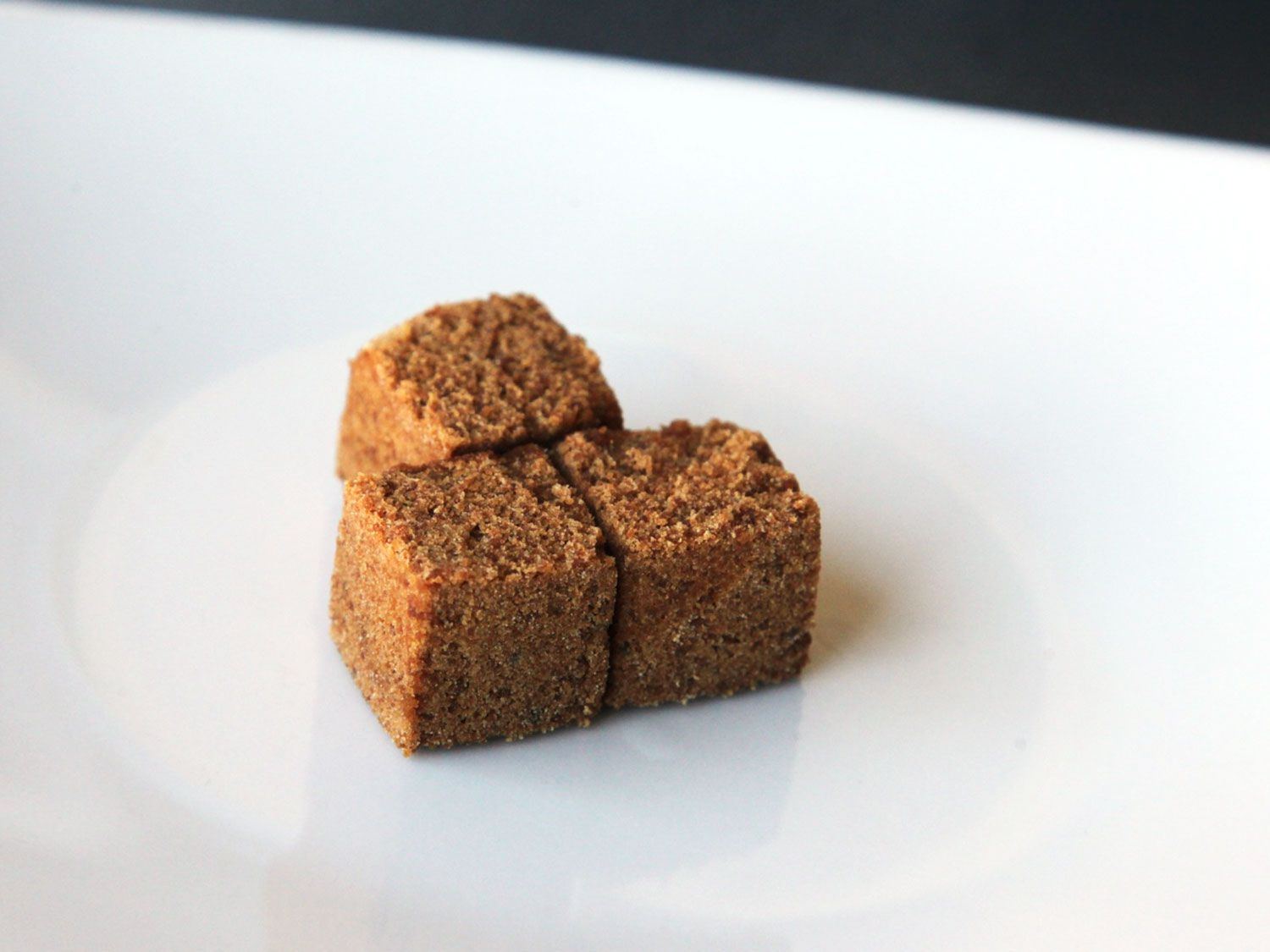Panela (evaporated cane juice) cubes on a white plate.