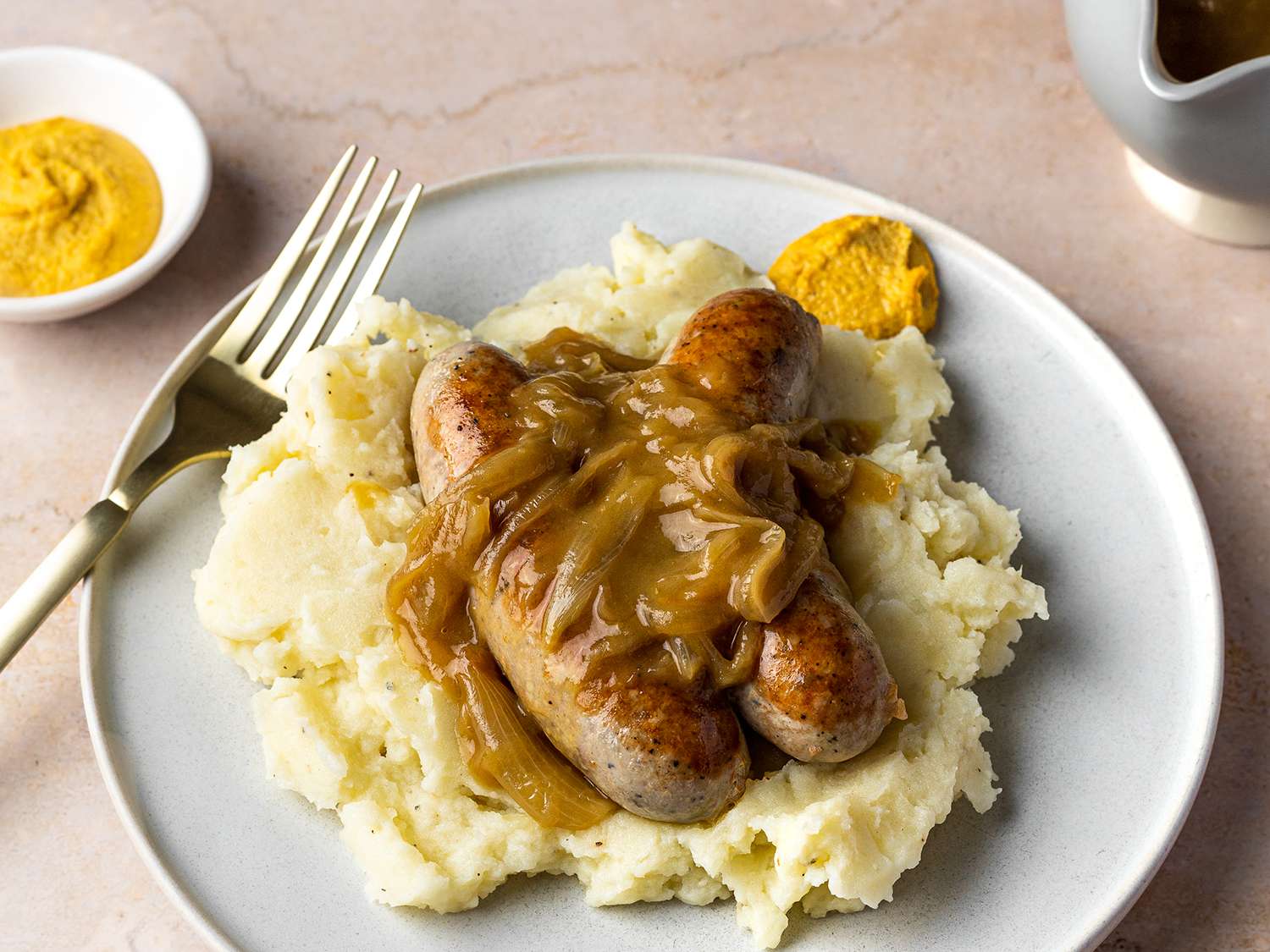 Sausage topped with onion gravy served on mashed potatoes