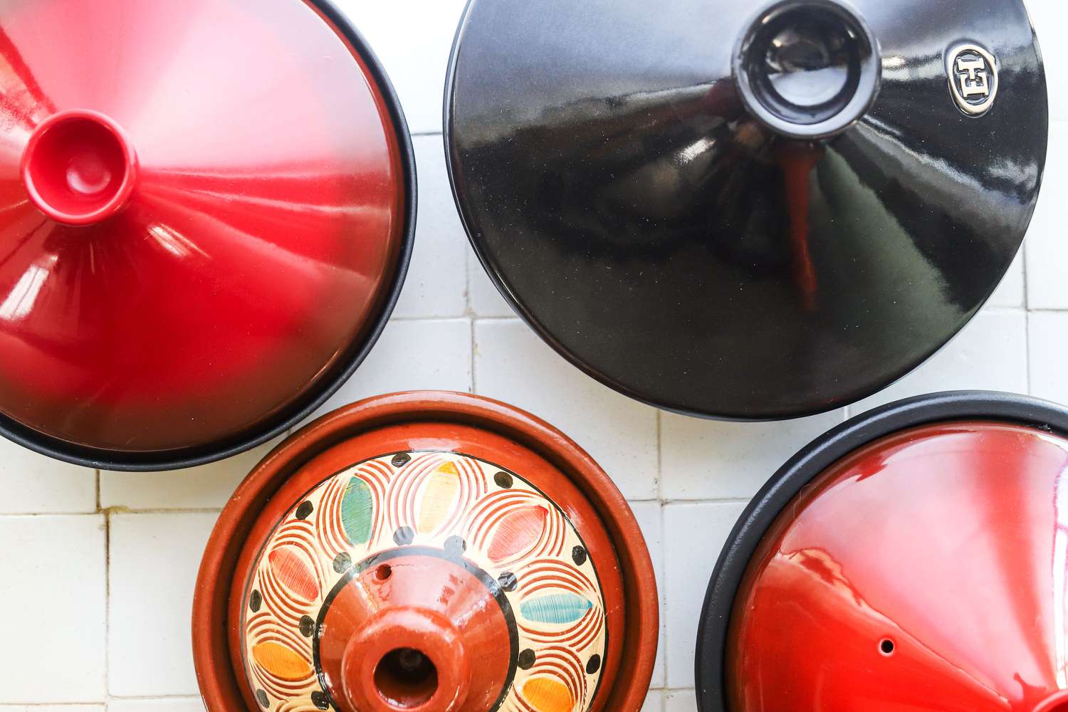 overhead shot of four tagines on a tile surface