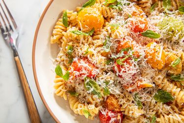 Bowl of pasta with roasted vegetables and grated cheese