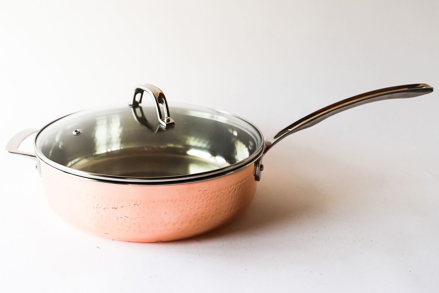 Copper saucepan with a glass lid and a stainless steel handle