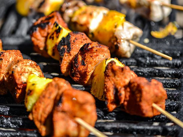 Closeup of the skewers getting charred on a grill.