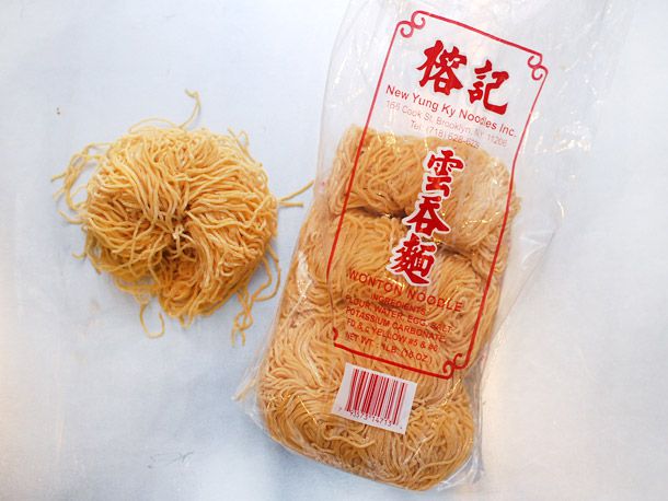 A package of thin wonton noodles with one pile out of the bag