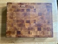 A well-conditioned maple cutting board on top of a table