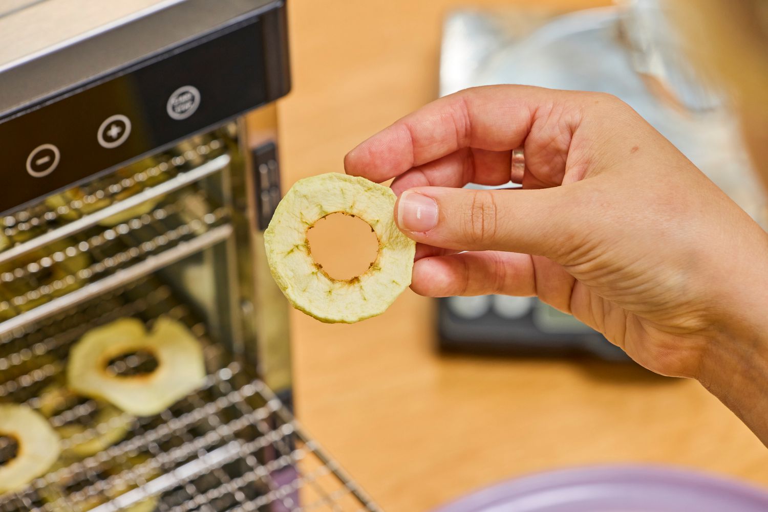 Person holding a food sample in front of COSORI Food Dehydrator