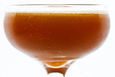 Closeup profile view of a Basin Street Blues cocktail, served in a coupe glass.