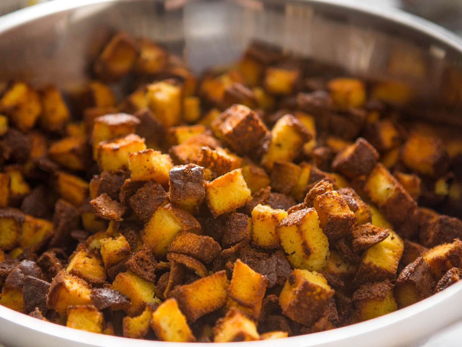 Cornbread cubes toasting in a skillet.