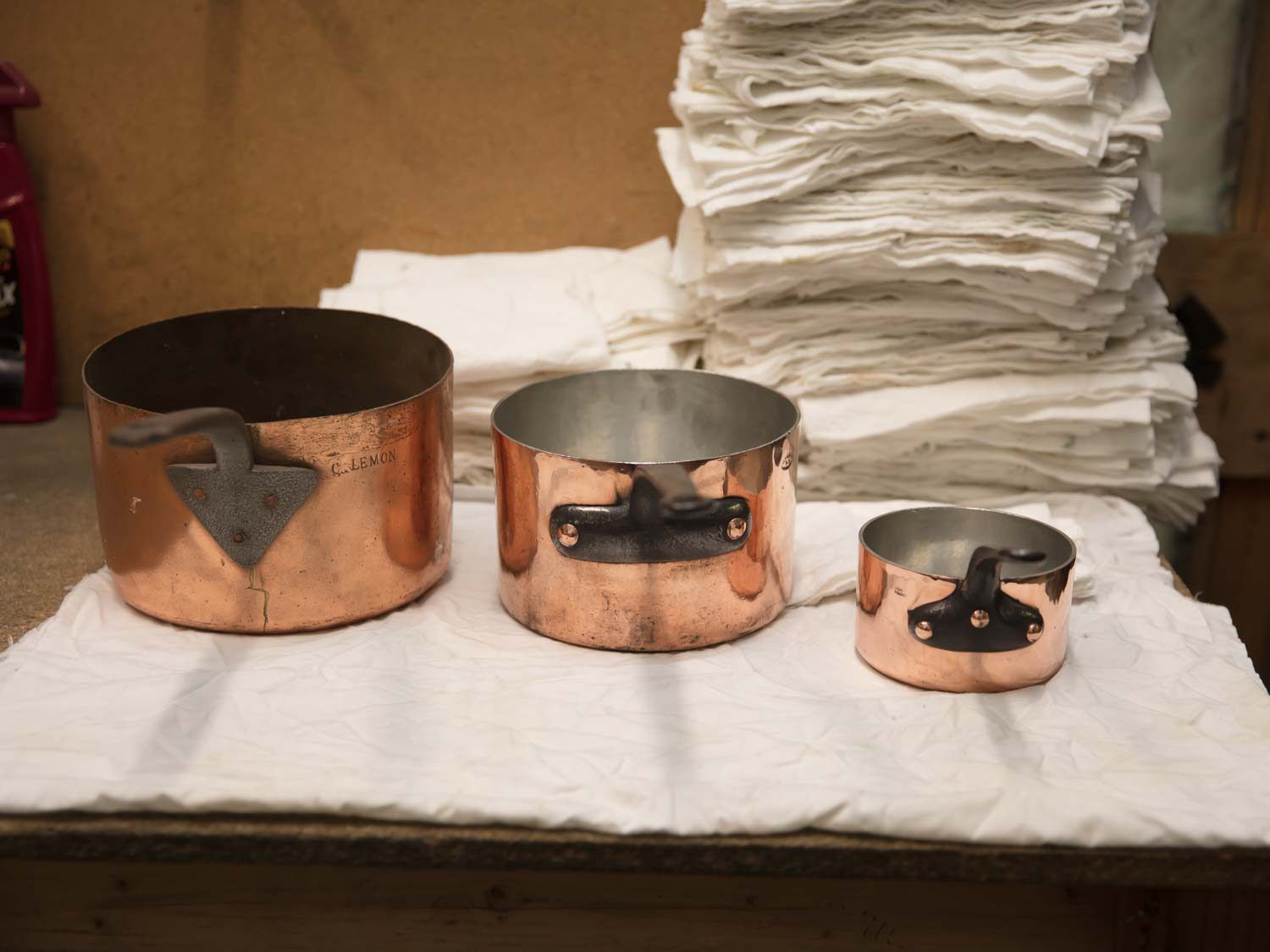 Three pieces of copper cookware, each showing a different handle design, which varies by country of origin