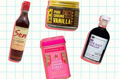 Assorted premium pantry items including bottles a tin of chili and a jar of vanilla against a grid background