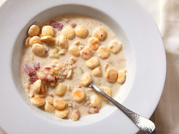 New England clam chowder topped with oyster crackers in a white bowl with spoon 