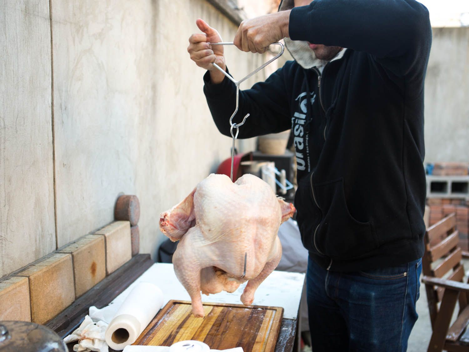 A person checking whether a turkey hanger has been attached correctly to turkey carcass