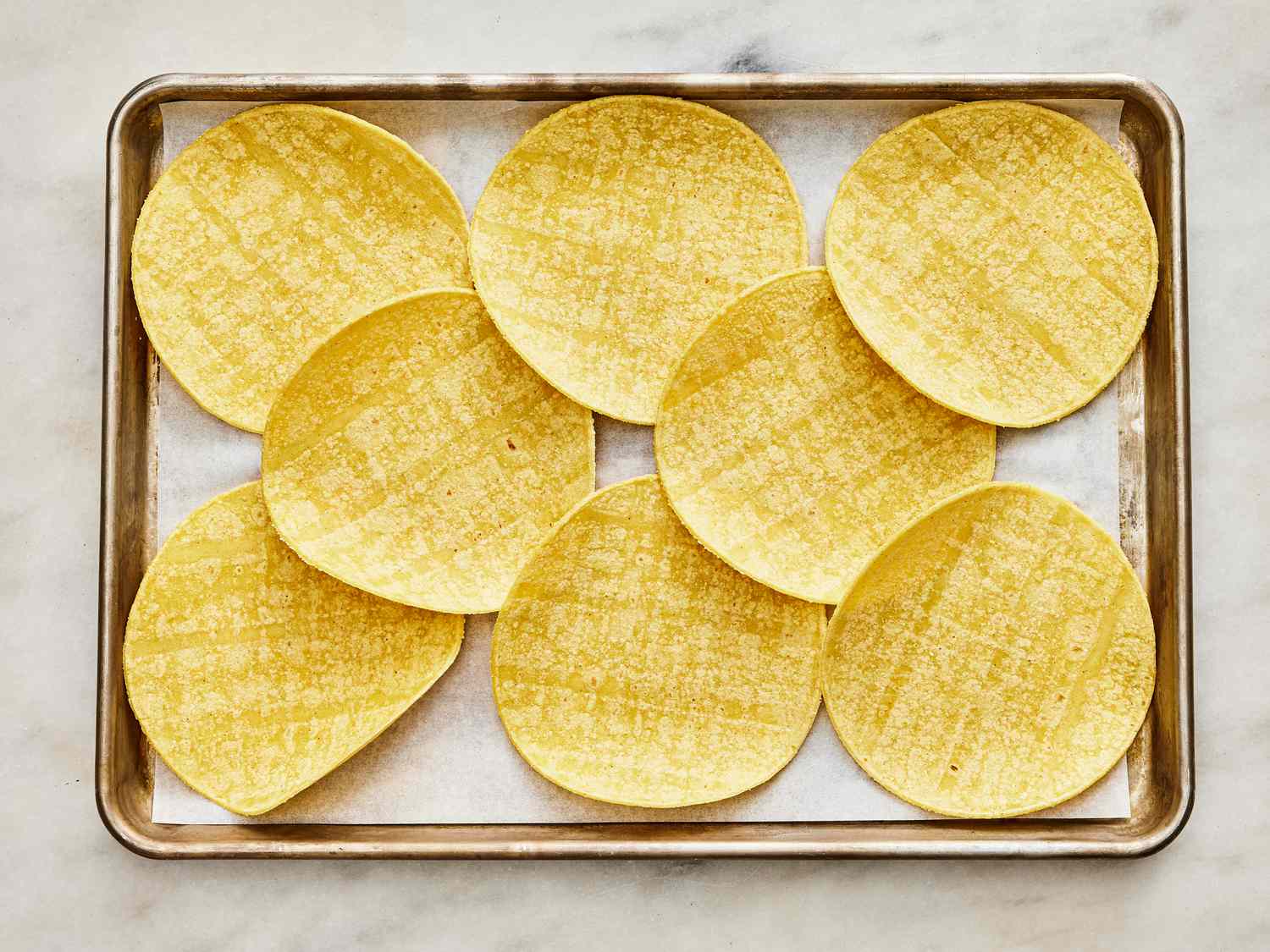 Sheet pan with tortillas arranged on it 