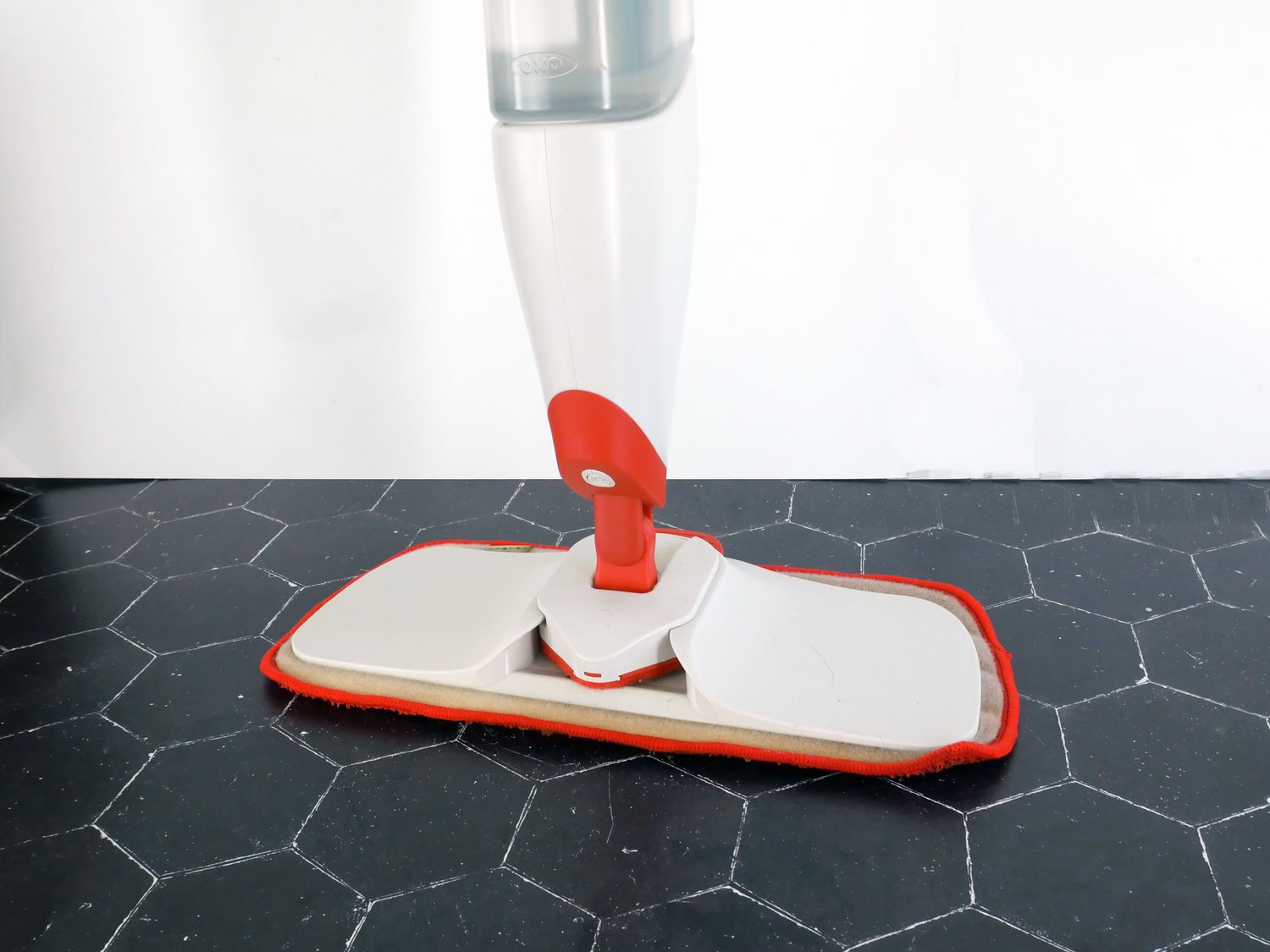 closeup of oxo mop on black tile surface