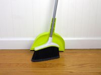 the casabella broom and dustpan leaning against a wall