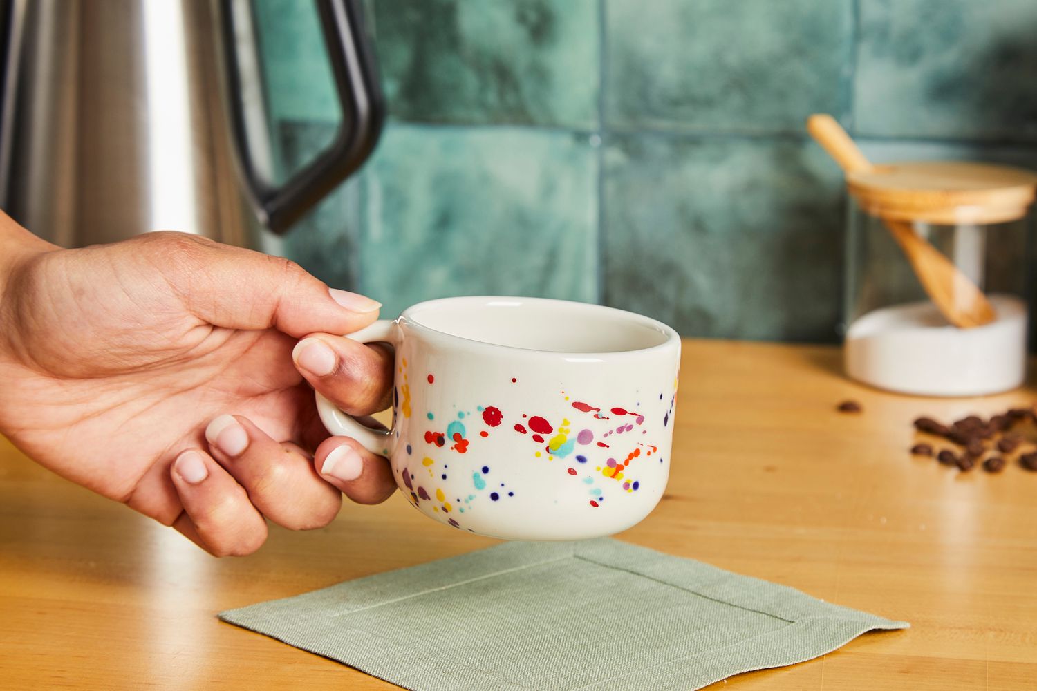 A person holding onto the handle of a Felt + Fat mug.