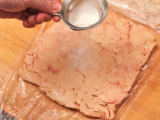 Sprinkling curing sat on a layer of foie gras for torchon. 