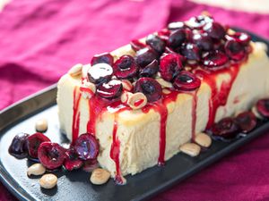 A loaf of honey semifreddo, topped with macerated cherries and Marcona almonds.