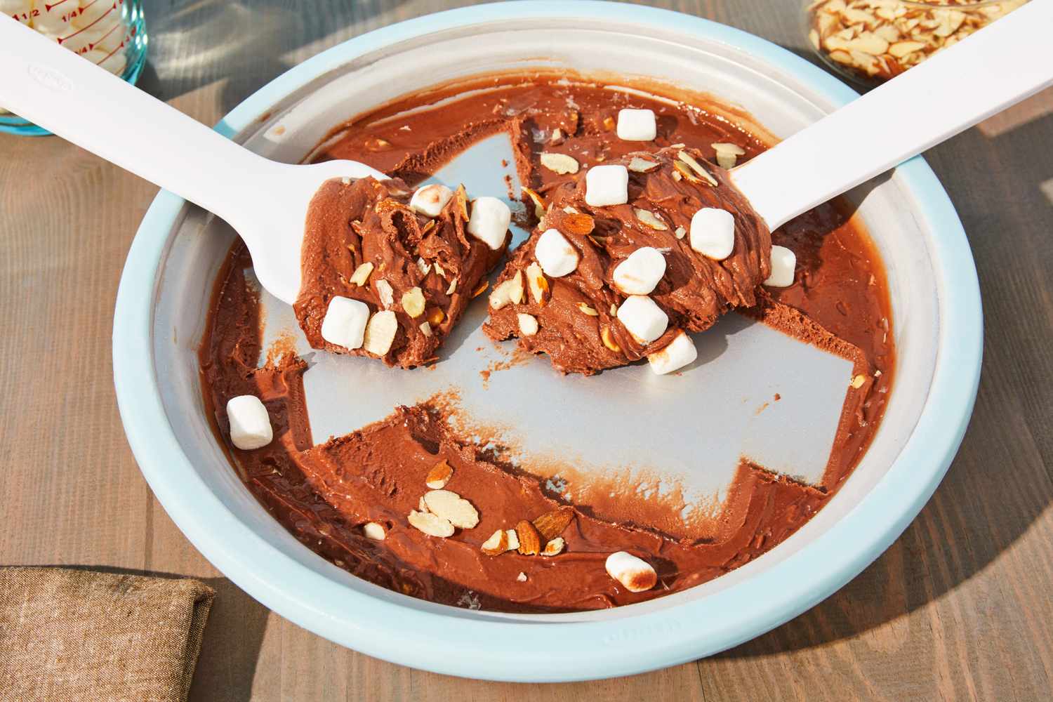 Two utensils showing ice cream with mini marshmallows from the Chef'n Sweet Spot Ice Cream Maker displayed on a wooden surface