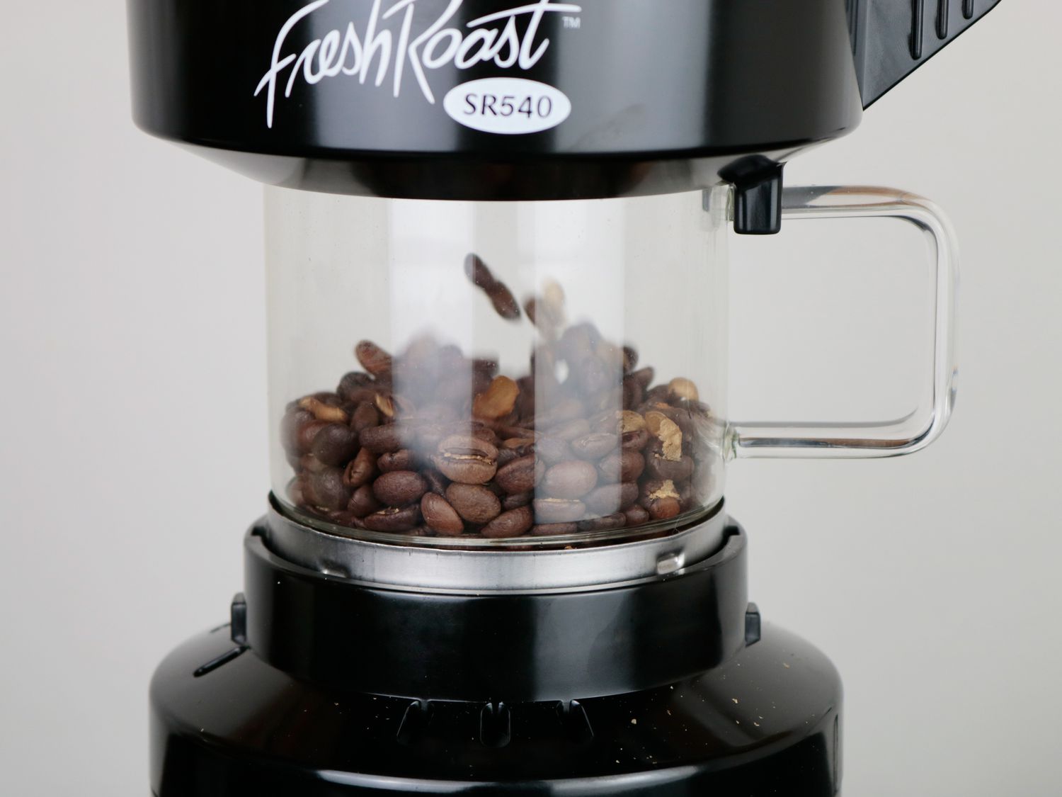 Coffee beans floating in the air in an air roaster