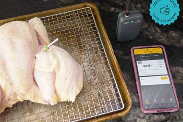 the probe stuck into a raw, butterflied chicken 