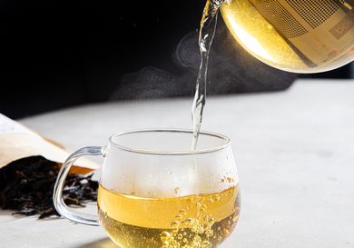 Tea going into a glass cup.