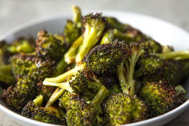 Close-up of roasted broccoli in a serving bowl.