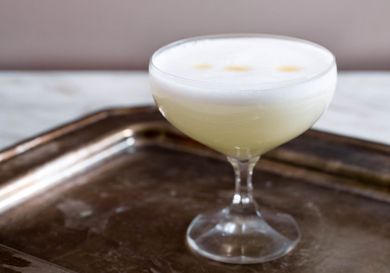 Pisco sour in a cocktail glass on a tray