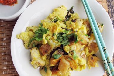 Overhead view of fried radish cake, served on a white plate.