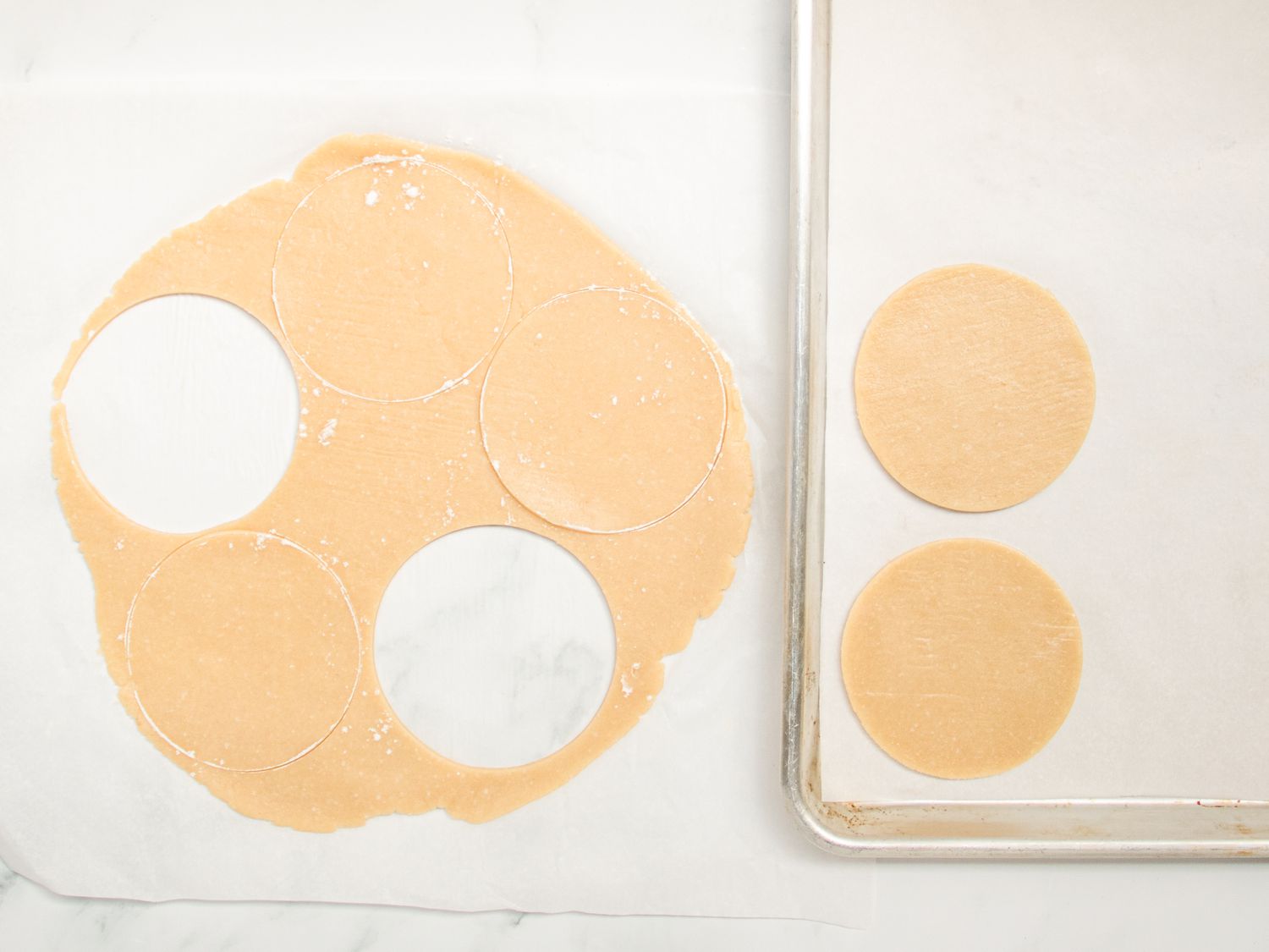 Dough rolled out, with 2 rounds taken out and placed on parchment lined baking sheet 