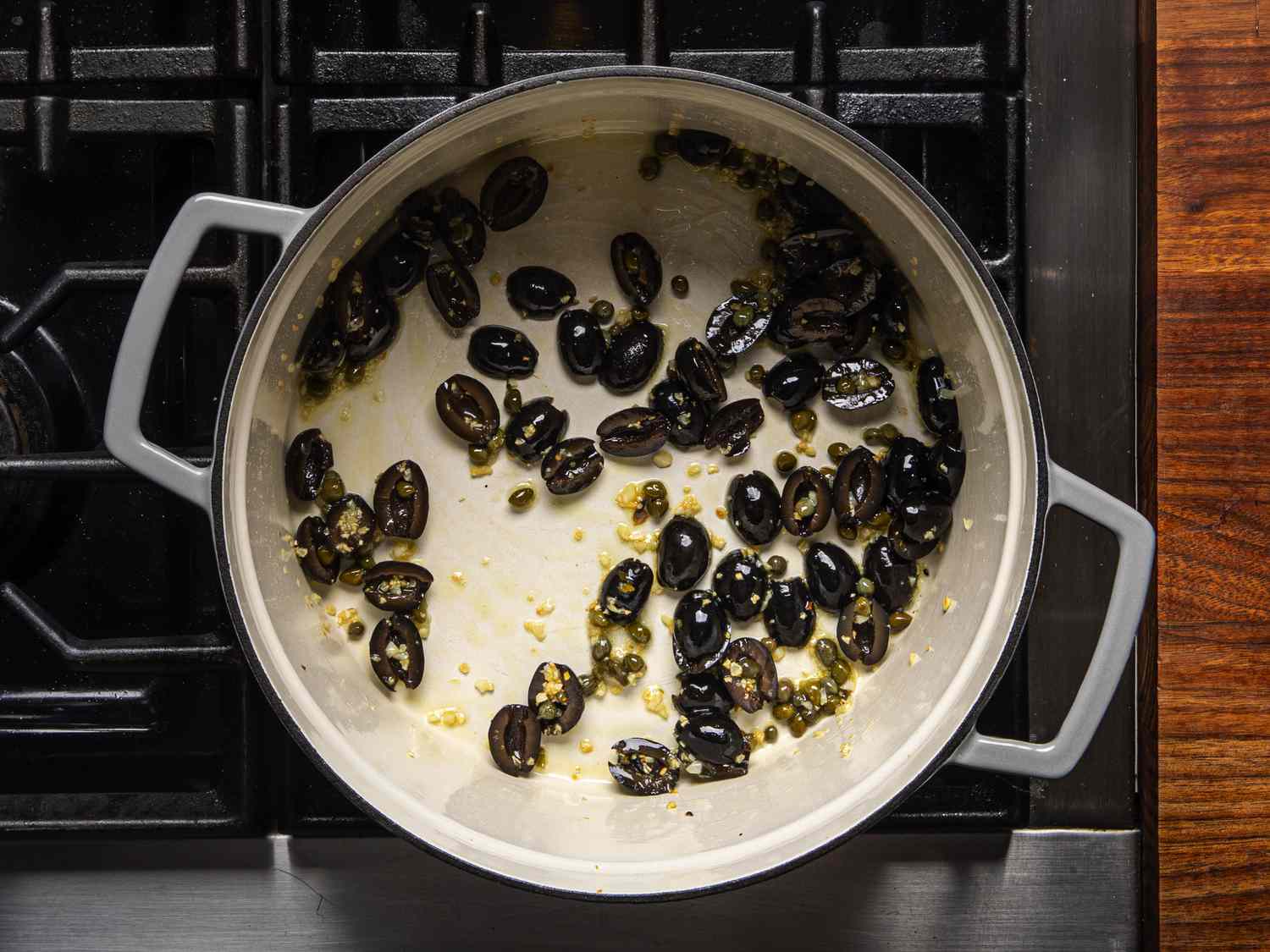Overhead view of black olives cooking in dutch oven