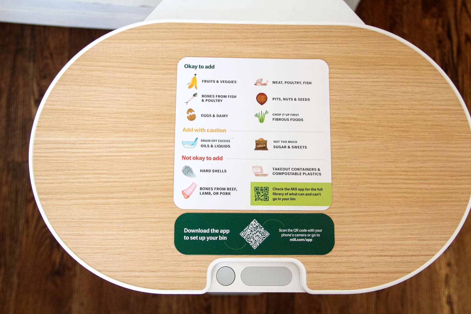 A composting guide on a wooden surface with a QR code and instructions for waste item classification