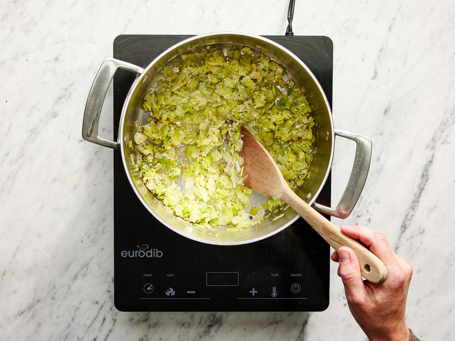 Stirring leeks and onions in the saucepan
