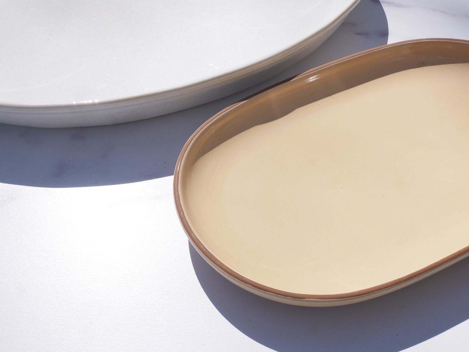 taller edged platter next to a shallow edged platter