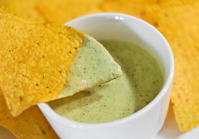 Tortilla chip dipped in salsa verde