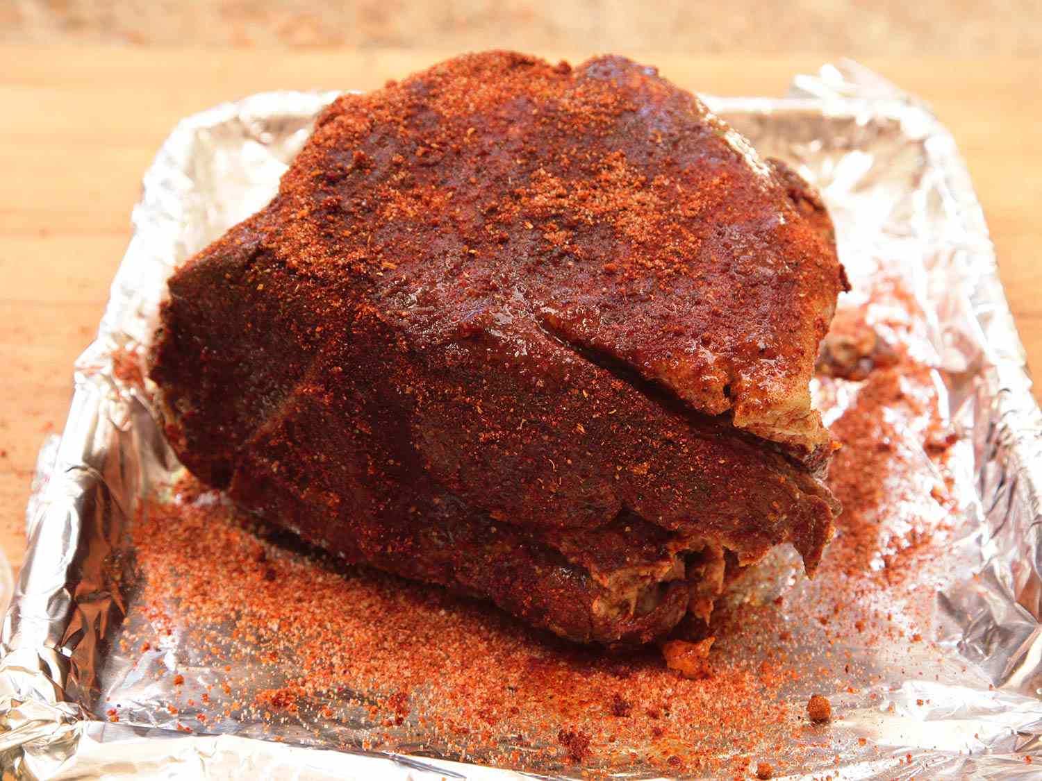 A pork shoulder with reserved half of spice rub reapplied after sous vide cooking.