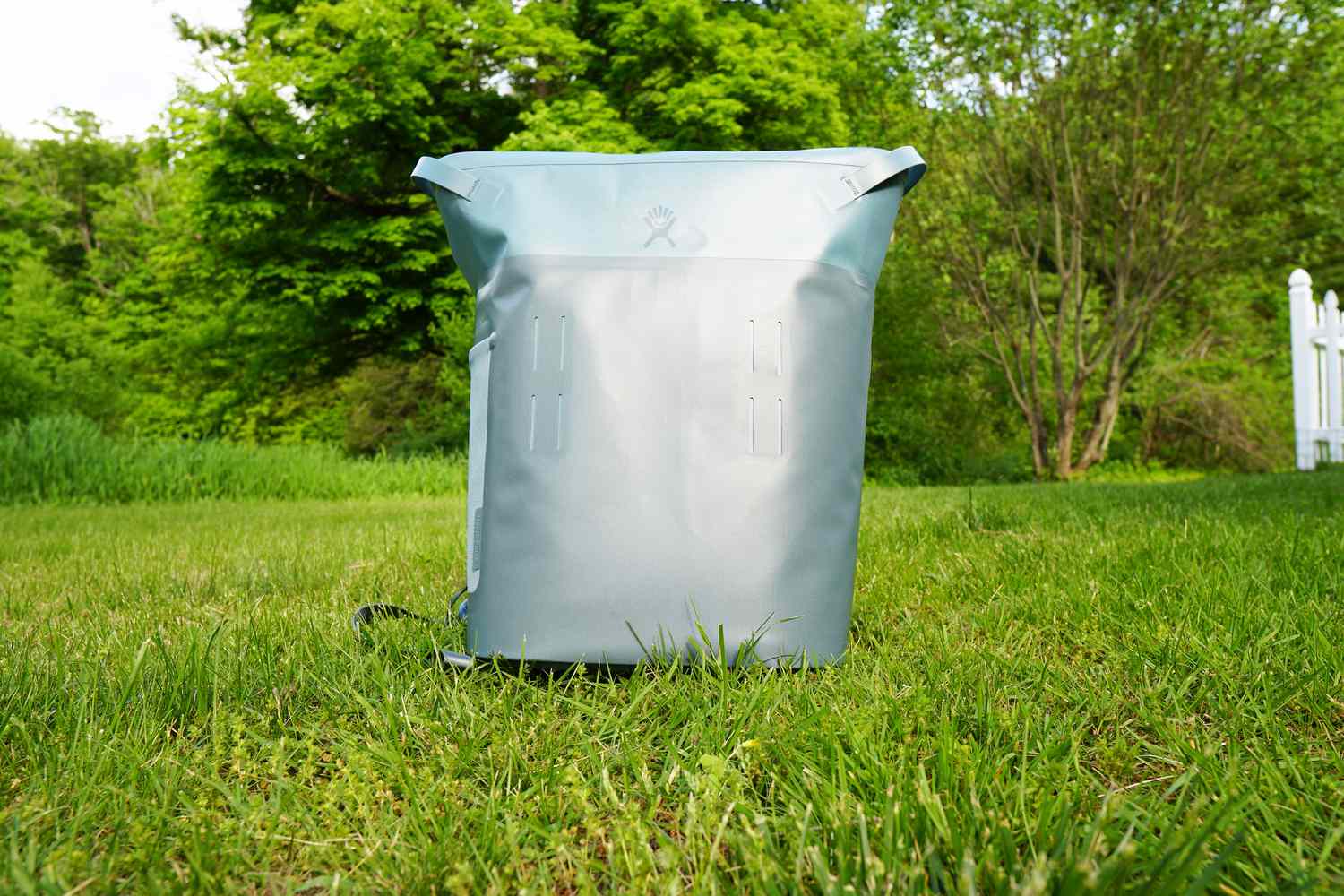 a blue backpack cooler on a grassy surface