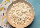 Overhead view of a bowl of tangy and creamy macaroni salad, served in a shallow bowl.
