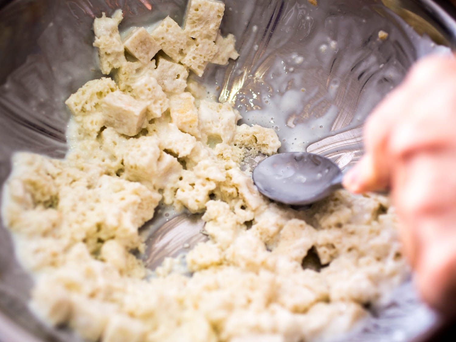 Mashing bread soaked in buttermilk to make panade for meatballs.