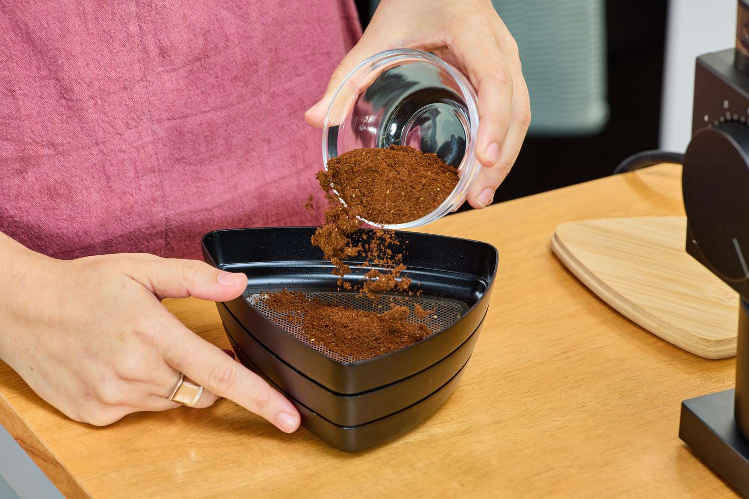 A person pours coffee grounds from the Fellow Ode Gen 2 Coffee Grinder onto a plate