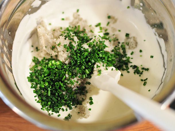 Crème fraîche, horseradish, chives, lemon juice, salt, and pepper added to the heavy cream in a bowl