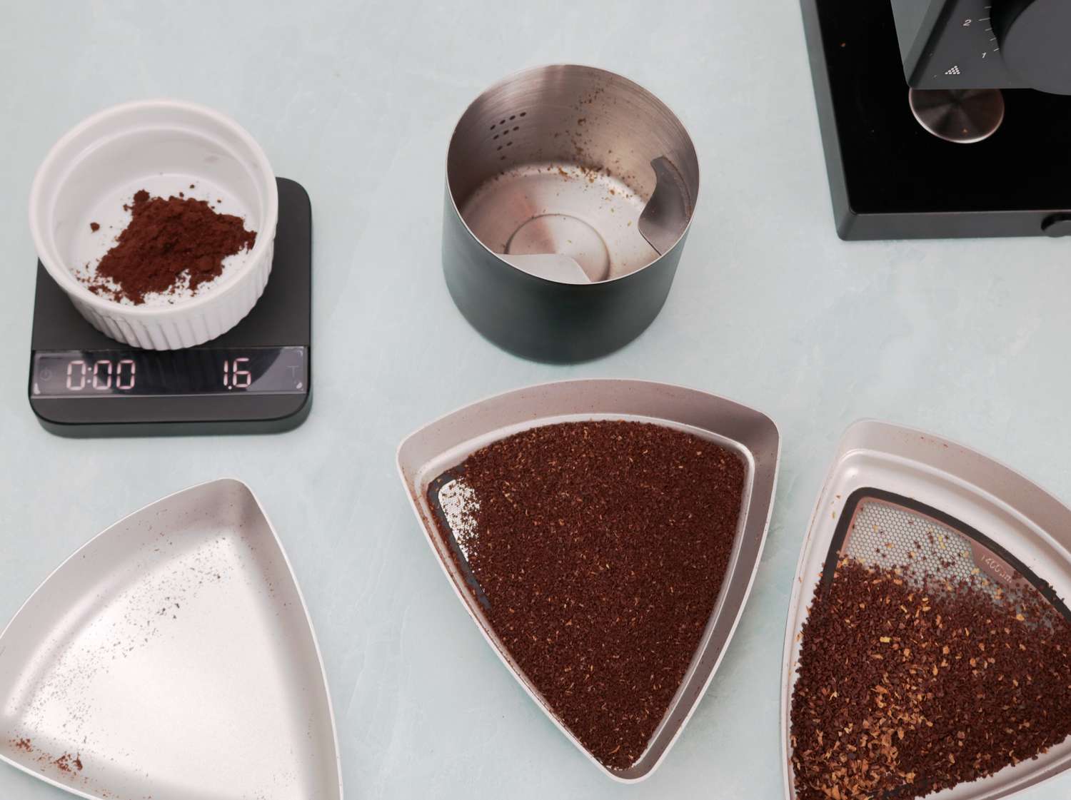 coffee grounds separated into three different containers after being sifted for size