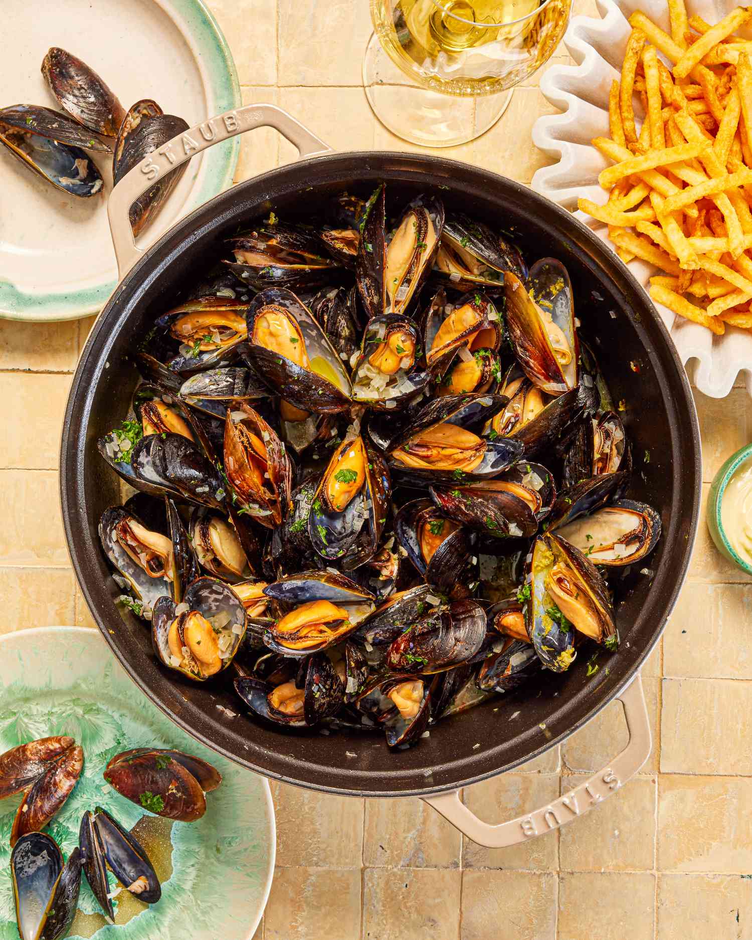 Mussels in a grey Dutch oven with a side of fries.